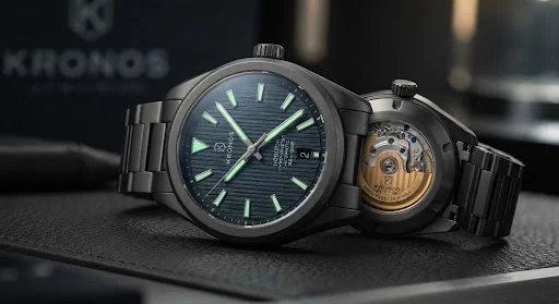 Detailed macro product photo of the KRONOS Horizon Chronometer 41mm with a dark bead-blasted Grade 5 titanium case, deep slate textured dial, glowing tritium hands, and exhibition back with golden oscillating rotor, sleek luxury presentation