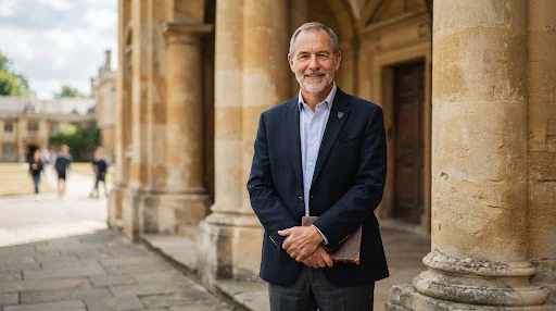 Portrait of a distinguished male faculty member against architectural university limestone pillars in daylight