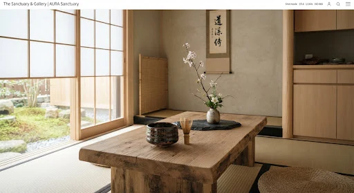 Serene Japanese tea ceremony alcove inside a modern luxury longevity clinic, hand-glazed dark ceramic matcha bowl, raw cypress wood low table, minimalist ikebana flower arrangement on dark slate, quiet aesthetic